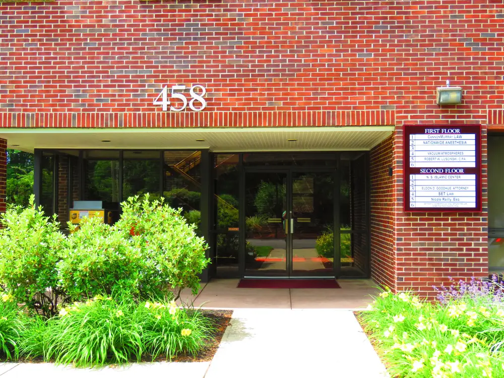 The front entrance of 458 Boston Street, with the number 458 above the door and the tenant directory board on the wall to the right.