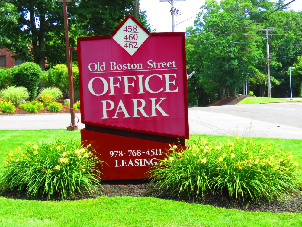 Red sign at the roadside reading Old Boston Street Office Park, listing numbers 458, 460 and 462.